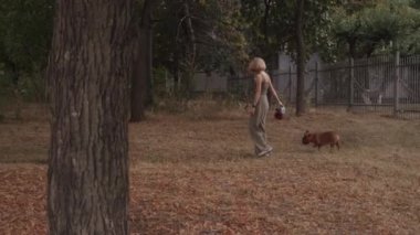 Genç bir kadın, sevimli köpeğiyle sakin bir parkta dolaşmaktan keyif alıyor. Yürek ısıtan bir arkadaşlık ve aşk sahnesi yaratıyor..