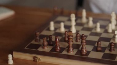 Beyaz gömlek giyen bir iş kadını evinde ya da ofisinde satranç oynuyor. Bir satranç taşı aldı ve tahtadaki bir sonraki hamlesini düşündü.. 