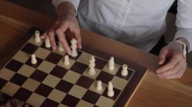 Bir satranç oyununda bir sonraki hamlesini düşünürken bir iş kadınının ellerini kapat. Ofisinde kendisine karşı oynuyor..