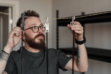 Film negatiflerini geliştirmeye odaklanmış, fotoğraf geliştirme sürecini ve detaylara dikkat çeken bir adam..