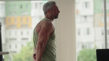 Spor salonundaki güçlü adam antrenmanını takdir ediyor. Zindelik, sağlık ve kendini geliştirme kavramı.