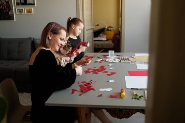 Yaratıcı sanat ve el sanatları ile uğraşan, bağ kuran ve gülümseyen bir ailenin neşeli bir anı. Aile mutluluğu ve sanatsal ifadenin mükemmel tasviri.