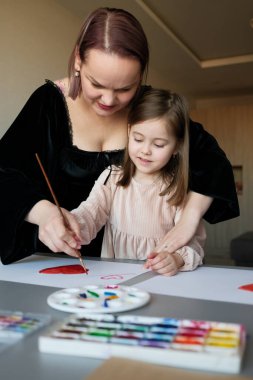 Bir ebeveyn ve çocuk resim üzerine bağ kurar, samimi bir ortamda sevgi ve yaratıcılık gösterirler..