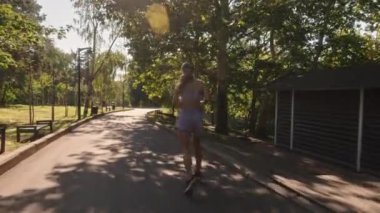 Genç bir kadın yaz aylarında spor yapmak için parkta koşuyor. Bu video fitness, sağlık, sağlık ve egzersiz temaları içerir..