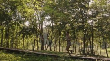 Genç bir kadın ağaçlık bir patikada sabah koşusunu seviyor. Müzik dinliyor ve ağaçların arasından parlayan güneşle bir ormanın içinden tepeye doğru koşuyor..