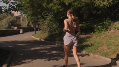 Genç bir kadın parkta koşuya çıkar. Spor kıyafetleri giyiyor ve kameradan kaçıyordu. Bu spor, sağlık ve sağlık için harika bir klip..