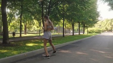 Genç sportif kadın yaz boyunca parkta koşuyor. Dışarıda spor yapan atletik bayan koşucunun arka görüntüsü. Fitness, spor ve sağlıklı yaşam tarzı kavramı.