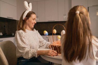 Anne ve kızı Paskalyayı yumurta sepetleri ve şenlikli süslemelerle kutluyor..