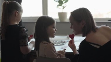 Anne ve kızları evde kalplerini birleştirirler. Aile zamanı, sanat ve zanaat..