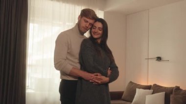 Birbirine aşık çiftler birbirlerine sarılıyorlar ve birbirlerine bakıyorlar..