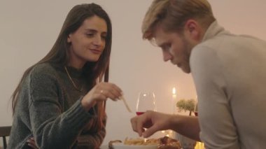 Çift, şarap, patates kızartması ve sohbet ile romantik bir akşam yemeği yer..