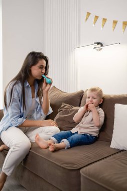 A loving mother and her child enjoy blowing balloons in a happy moment. clipart