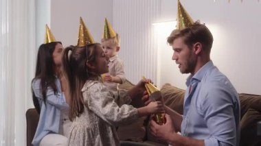 Aile doğum gününü ya da özel etkinliği parti şapkaları, balonlar ve hediyelerle kutlar..
