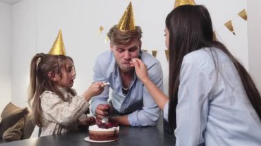 Aile doğum gününü pasta ve parti şapkalarıyla kutlar..