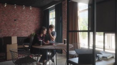 Yeni bir dairede tablet kullanan, içeriyi planlayan ya da faturaları ödeyen çift..