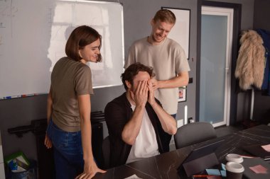 Masa başı bir projede birlikte çalışırken üç meslektaşımız aynı neşeli anı paylaşıyor..