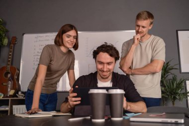 Modern bir konferans salonunda çalışırken fikirleri tartışan iş arkadaşları