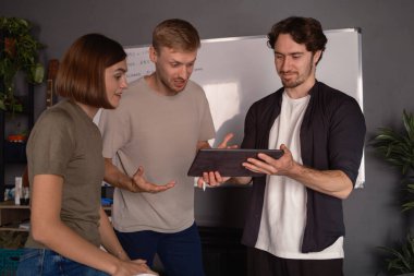 Modern ofis alanındaki bir ekranda iş birliği ve analiz yapan üç kişi