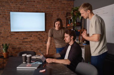 Yaratıcı bir çalışma alanındaki bir iş toplantısında beyin fırtınası yapan bir grup profesyonel.