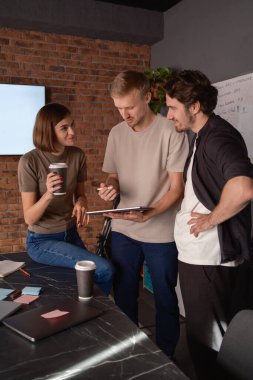 Meslektaşları profesyonel bir çalışma alanında masa etrafında fikirleri tartışıyor..