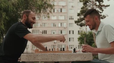İki arkadaş parktaki bankta satranç oynamaktan hoşlanıyor. Odaklanıyorlar ve eğleniyorlar. Maçtan sonra iyi bir sportmenlik sergileyerek el sıkışıyorlar..