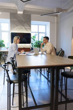 Parlak bir ofis ortamında iki profesyonel arasındaki iş görüşmesi