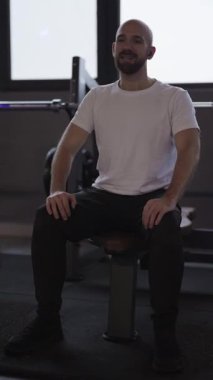 Spor salonundaki yoğun antrenmandan sonra dinlenen yorgun atletik adam..