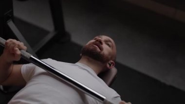 Spor salonunda ağırlık çalışması yapan bir adam..