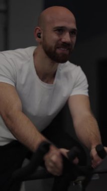 Adam spor salonunda egzersiz bisikletinde spor yapmayı seviyor..