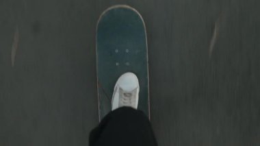 Beyaz spor ayakkabılarla pov fotografı. Asfalt yolda ya da yolda kaykay sürüyorlar. Etkin yaşam tarzı videoları için mükemmel.