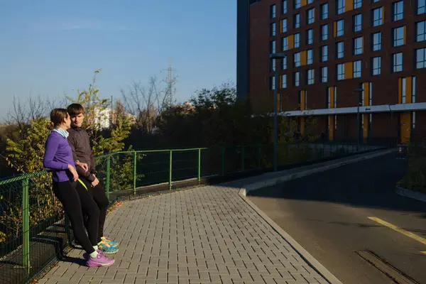 Güneşli bir günde şehirde koşuya çıkan çift.