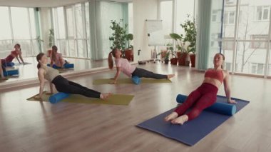 Bir spor salonunda köpük pateni egzersizi yapan üç kadın..