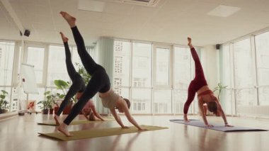 Stüdyoda birlikte yoga yapan üç kadın..