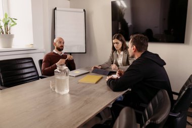 Ofis toplantısı sırasında iş stratejisinde işbirliği yapan üç profesyonel