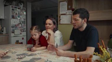 Aile evde kağıt oynuyor, birlikte vakit geçiriyorlar..