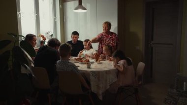 Büyük bir aile evde birlikte yemek yiyor..