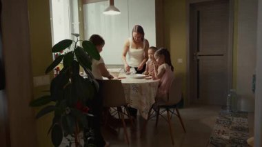 Aile mutfakta yemek hazırlar. Anne ve kızları birlikte yemek pişirir..