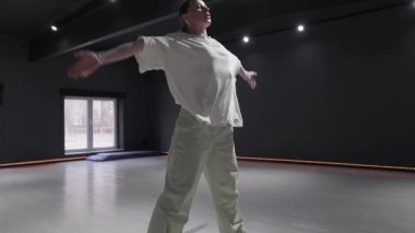 Dans stüdyosunda yalnız dans eden bir kadın. Koreografi provası. Modern bale.