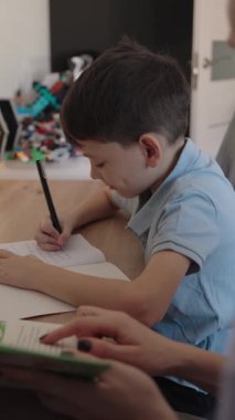 Oğluna ev ödevinde yardım eden, öğrenme ve aile bağlarını güçlendiren bir annenin yürek ısıtan bir sahnesi..