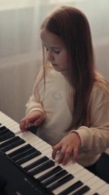 Genç bir kız evinde oturur ve piyano çalar. Piyano çalmayı biliyor ve müzik dinlemeyi seviyor..