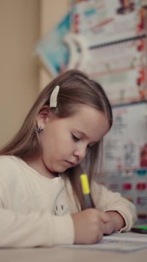 Genç bir kız ödevlerini özenle yapıyor, derslerine odaklanıyor ve meşgul oluyor..