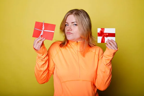 Seriös Ung Kvinna Orange Shirt Håller Två Presentkort Isolerade Gul Royaltyfria Stockfoton