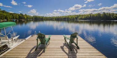 Two Ontario chairs sitting on a wood cottage dock clipart