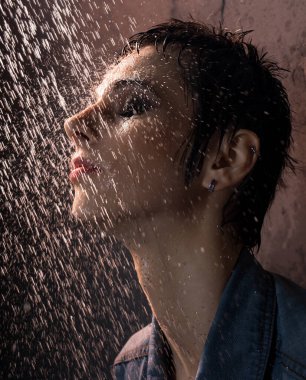 Jeans t-shirt sahip güzel esmer karanlık oda portre duşta