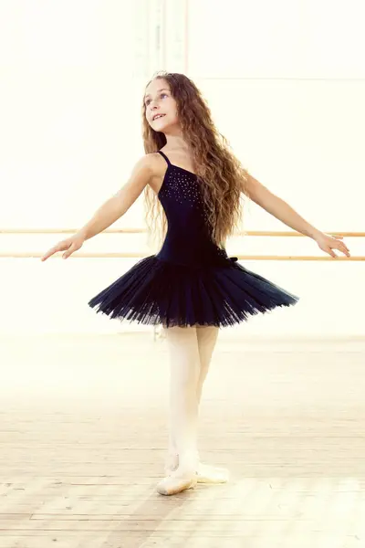 Image of emotional little dancer posing in ballet studio