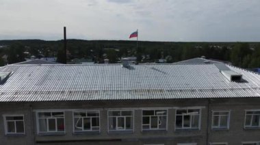 Küçük Rus şehri Yurya 'da çatısı Rus bayrağıyla döşenmiş eski tuğladan bir evin çatısı.