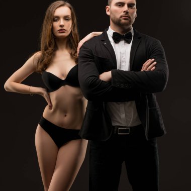 Genç seksi adam beyaz gömlek, takım elbise ve kravat siyah iç çamaşırı giyen kız arkadaşı ile atış kırpılmış