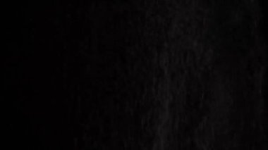 Beyaz unu elekten geçirerek elemek siyah arkaplana karşı tepeden düşmek