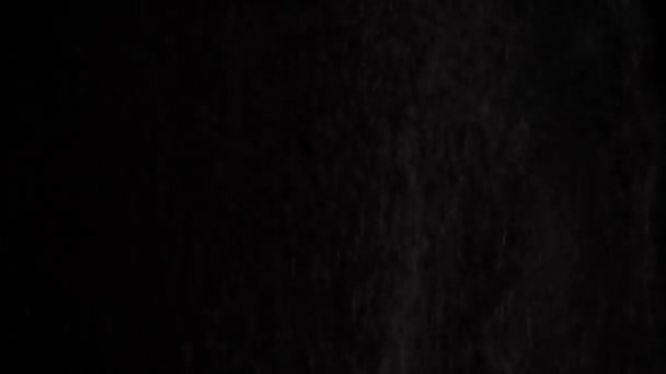 上から黒い背景に落ちるふるいを通した白い小麦粉のダイナミックなシフティング — ストック動画