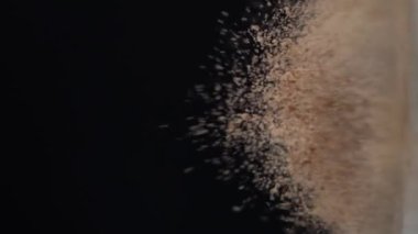 Kakao tozu, şefin hazırladığı siyah arka planda nefis bir yemek için kumaştan sekiyor.